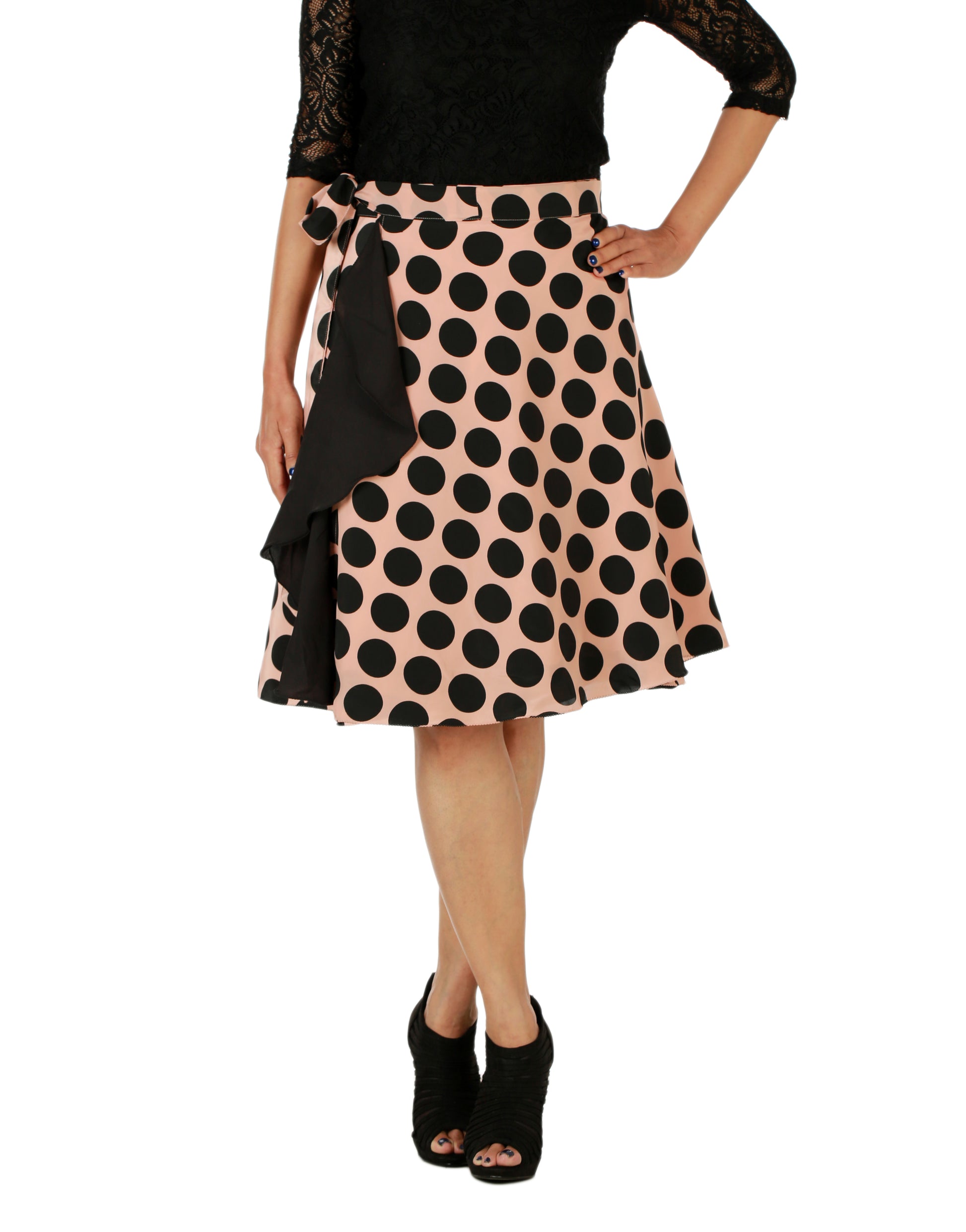 Woman wearing a free Size peach wrap skirt with black polka dots and ruffles at one end on a white background WA000154